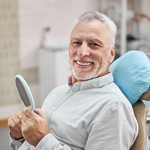 senior man smiling after getting dentures in Lincoln 