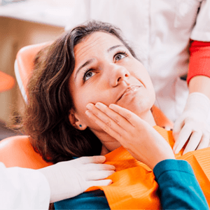 Woman with mouth pain, talking to dentist