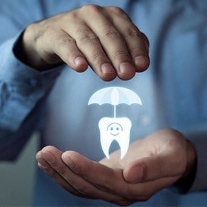 Hands holding animated tooth under umbrella