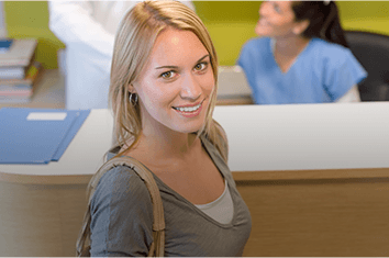 Smiling woman at dental reception desk