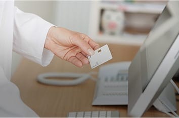 Dental team member entering dental insurance information on computer