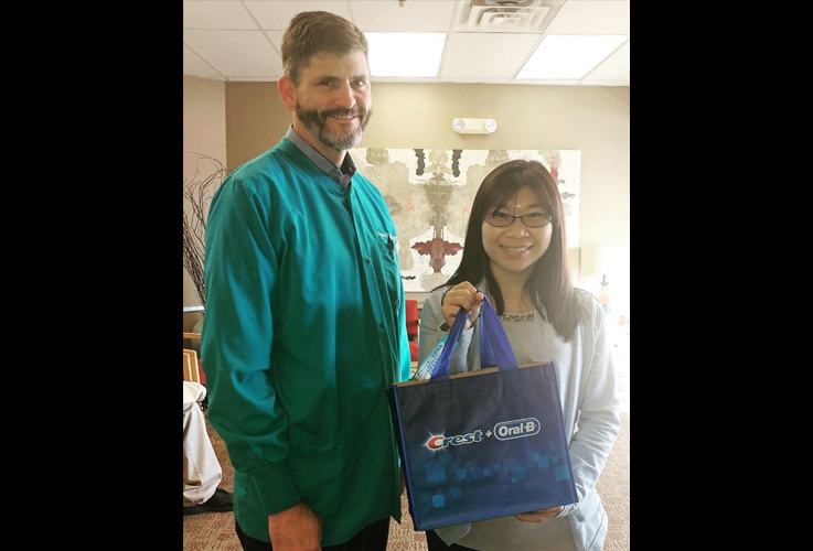 Doctor Shaffer giving dental patient a gift bag