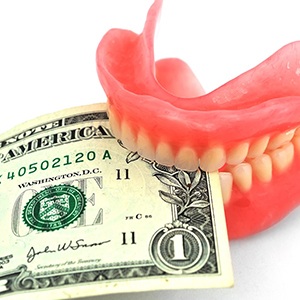 Upper and lower dentures with money gripped between them