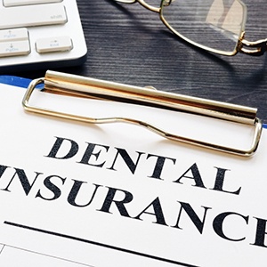 Dental insurance form with pen, next to keyboard