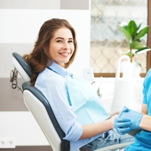 A female patient and her dentist smiling