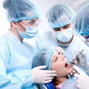A patient having her teeth worked on by three dental professionals