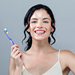 Woman holding a toothbrush while smiling