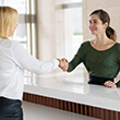 Dentistry team member and dental patient shake hands