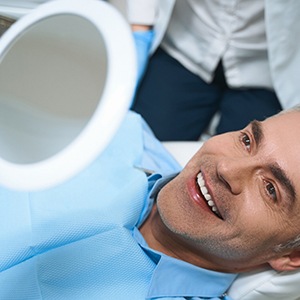 A man looking at his newly restored smile