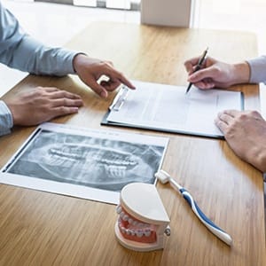 Dentist and dental patient discussing the parts of a dental implant restoration