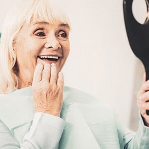 Woman admiring her new dental implants in Lincoln