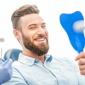 Young man admiring his new dental implants in Lincoln