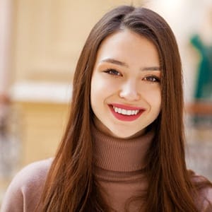 A young woman with metal free dental crowns smiling