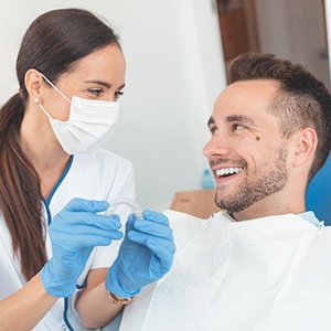 Dentist and patient smiling while discussing nightguard