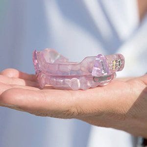 Hand holding a custom oral appliance