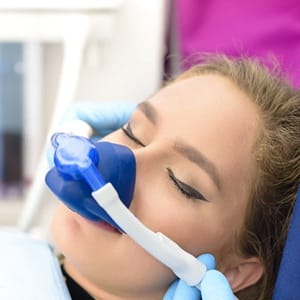 Woman receiving nitrous oxide from sedation dentist in Lincoln