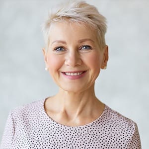 An older woman showing off her beautiful new smile thanks to veneers