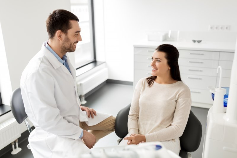 person whose veneer fell off speaking with dentist