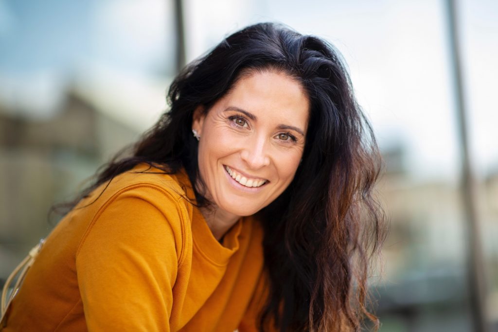 Mature woman with beautiful smile standing outside