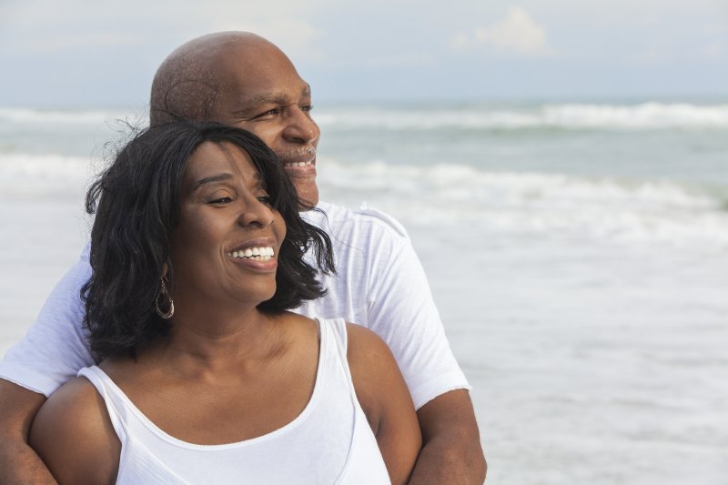 husband and wife smiling on the beach