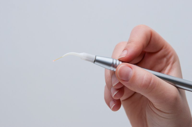 a person holding a laser dentistry tool in Lincoln