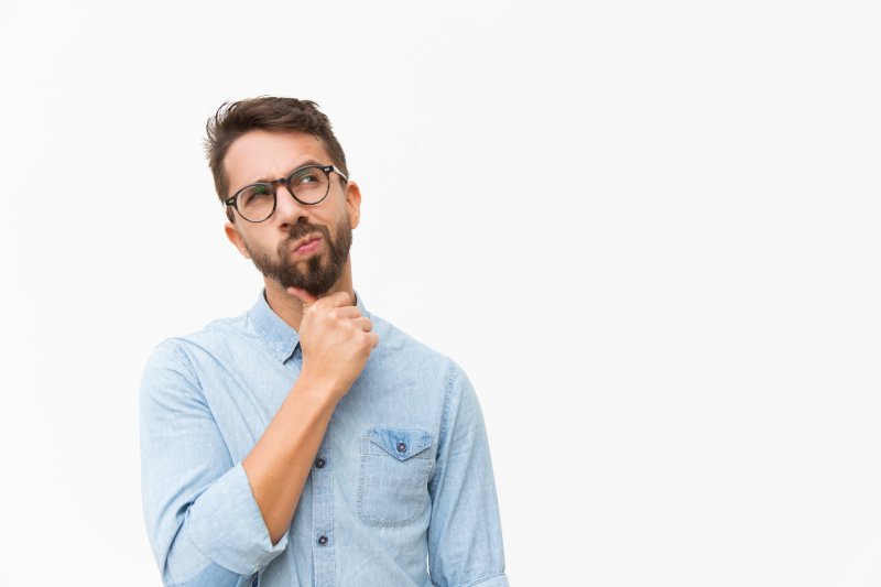 A man with glasses considering root canal treatment