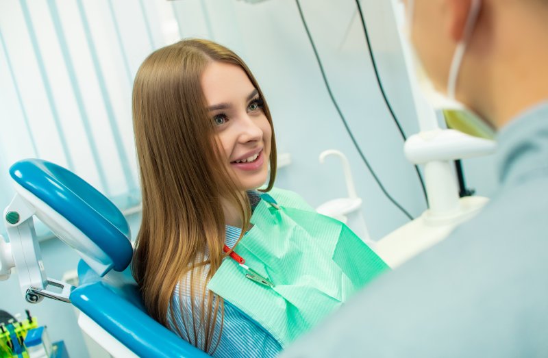 A patient talking with her dentist during an early dental checkup