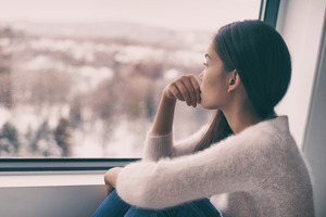 Woman with depression looking out a window