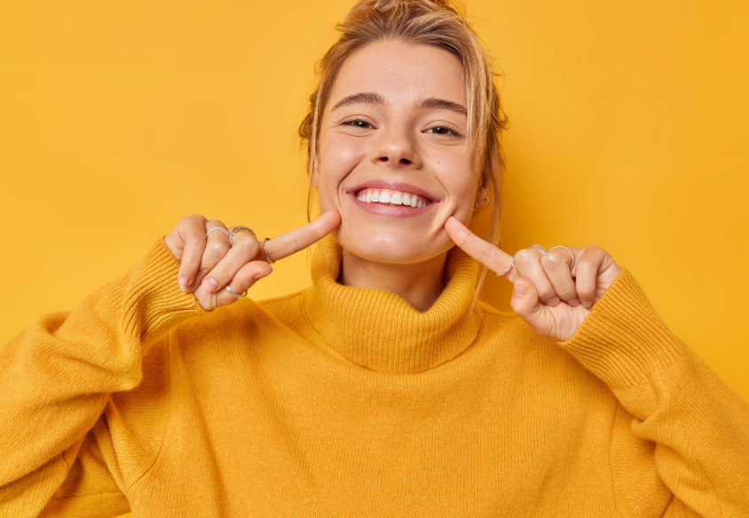 Woman pointing at her smile