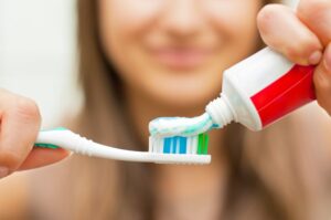 Woman putting toothpaste on her toothbrush
